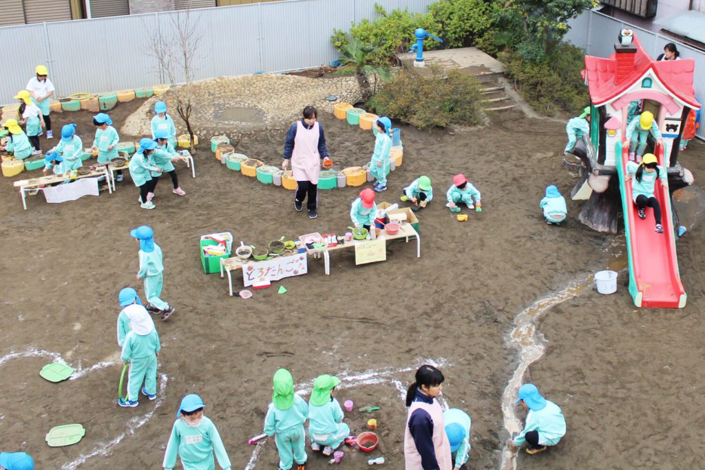 神戸幼稚園　園庭で遊ぶ園児と先生写真